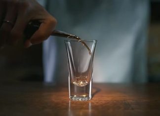Bartender pouring rum into glass